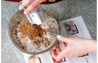 Woman pouring espresso powder into a bowl with flour